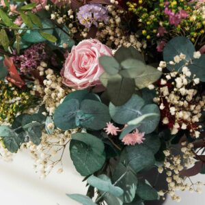 Precioso centro de flores preservadas con media docena de rosas en tono rosa y variedad de florecitas tipo glixias, statice, limonium, gypsophila....