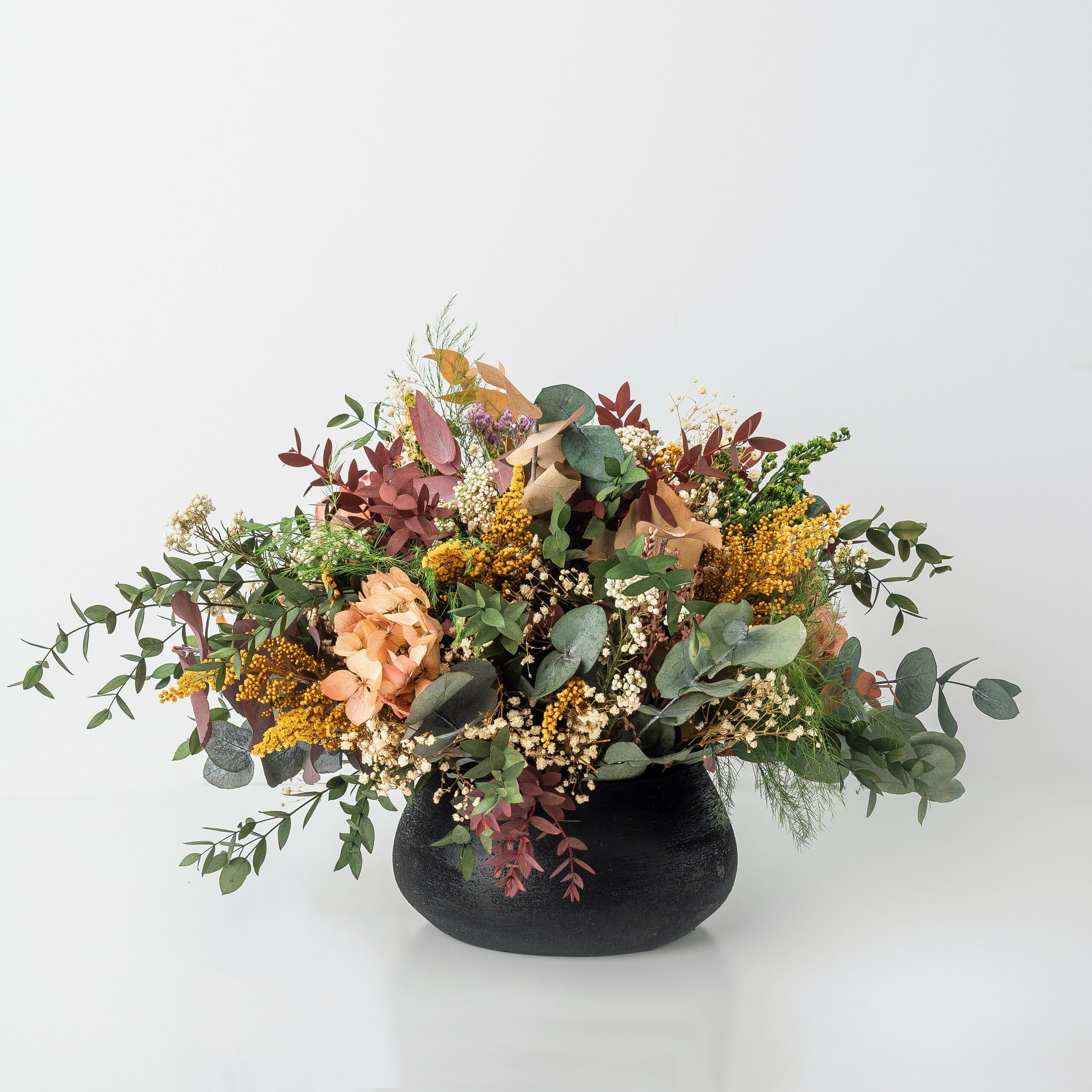 Centro de mesa tipo jarrón con flores secas y flores preservadas